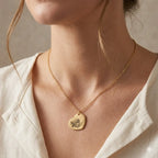 Gold heart pendant necklace with engraved dog portrait, a sentimental keepsake worn on a delicate chain.